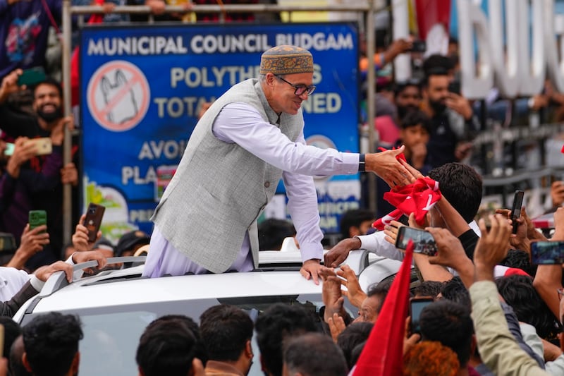 Jammu and Kashmir National Conference (JKNC) party leader Omar Abdullah shakes hands with supporters as he celebrates his victory (Dar Yasin/AP)