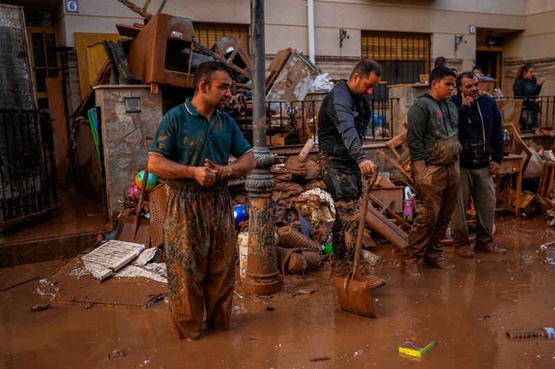 People clean their houses affected by floods in Utiel (Manu Fernandez/AP)