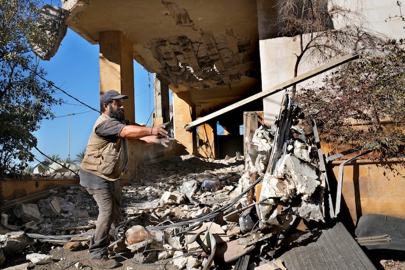 A worker removes the debris of a building that housed the office of pan-Arab TV channel Al-Mayadeen on Thursday (Hussein Malla/AP)