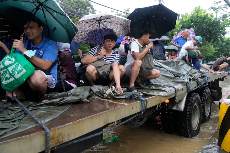 Filipinos evacuate in the city of Cainta, located in the province of Rizal, east of Manila (AP Photo/Aaron Favila)