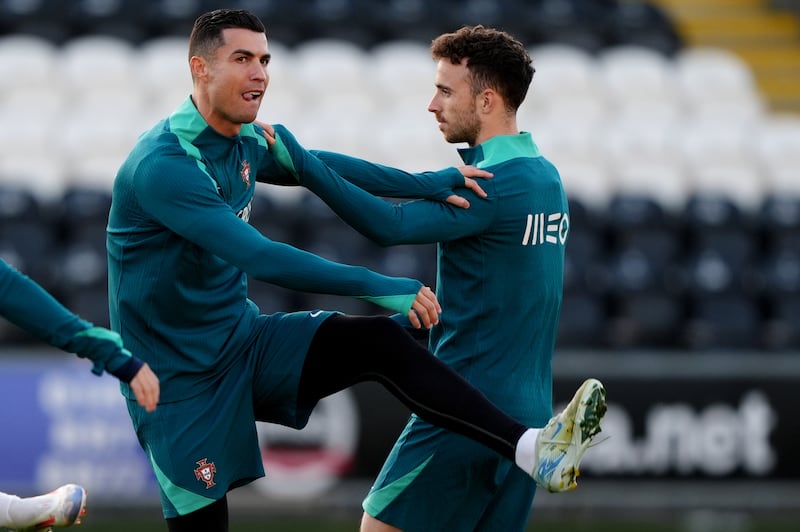 Ronaldo (left) and Diogo Jota (right) warm up in Paisley on Monday