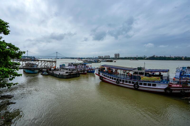 Boats are moored on Hooghly River in India after ferry services were suspended due to the approaching tropical storm Dana (Bikas Das/AP)