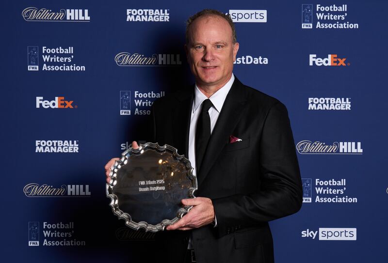 Dennis Bergkamp, pictured holding his award during the FWA’s Tribute Night in London on Sunday, was named in honour of Denis Law