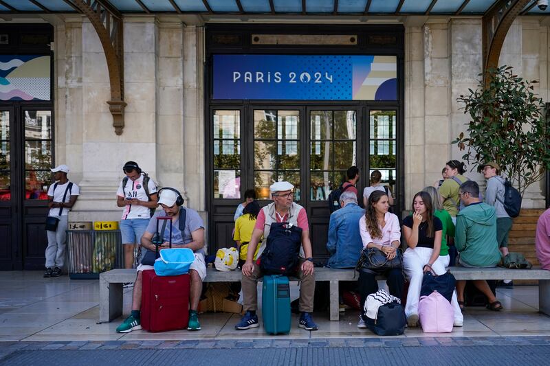 Travellers wait outside the Gare de Bordeaux Saint-Jean railway station after trains were severely disrupted (Moises Castillo/AP)