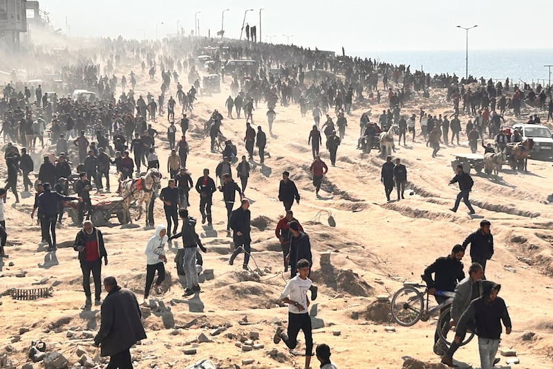 Palestinians wait for humanitarian aid on a beachfront in Gaza City (Mahmoud Essa/AP)