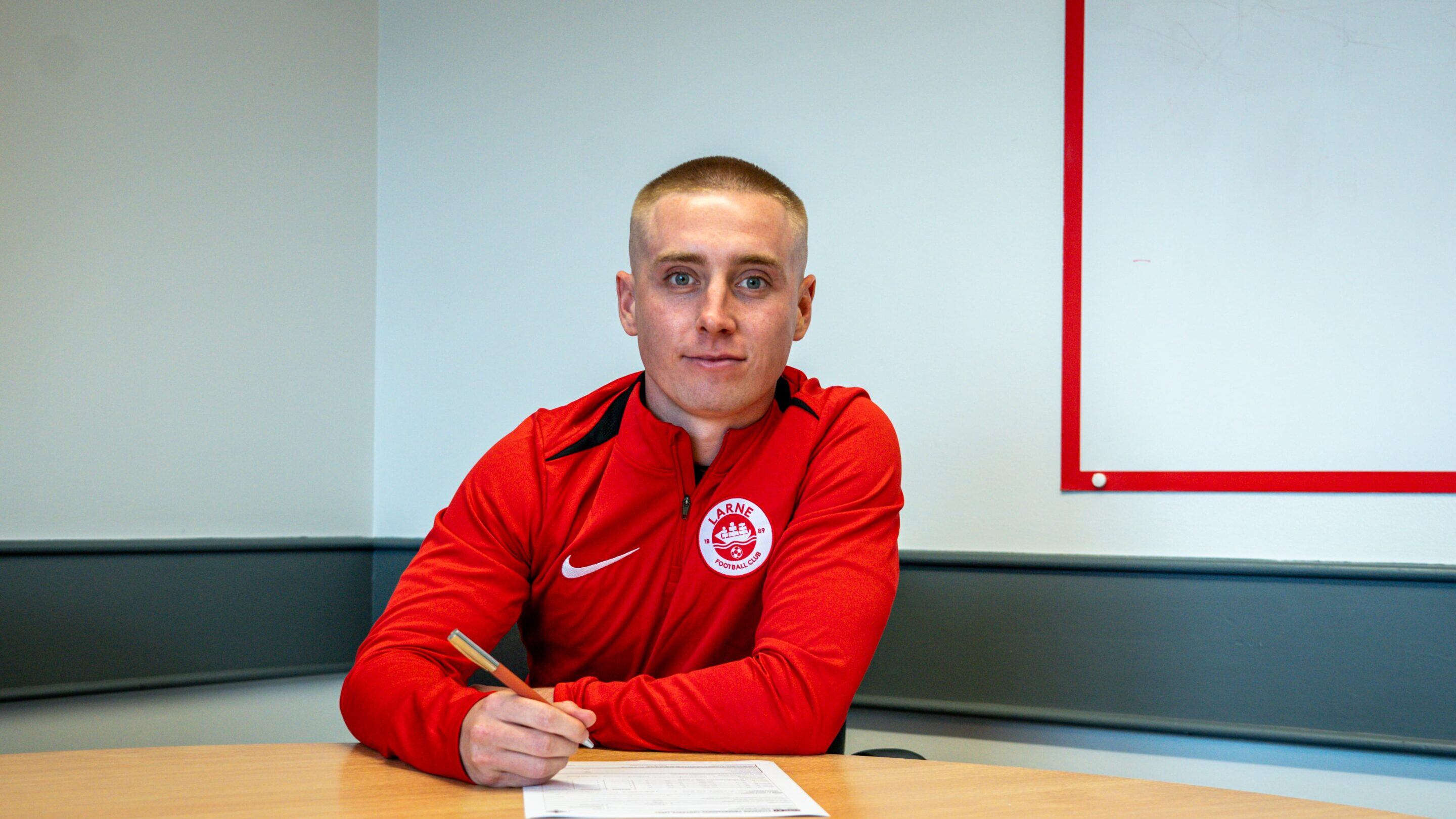 Conor McKendry signs on the dotted line as he returns to Larne