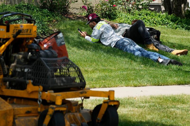 Workers take a break during hot weather as parts of the United States braces for extreme heat (Nam Y Huh/AP)