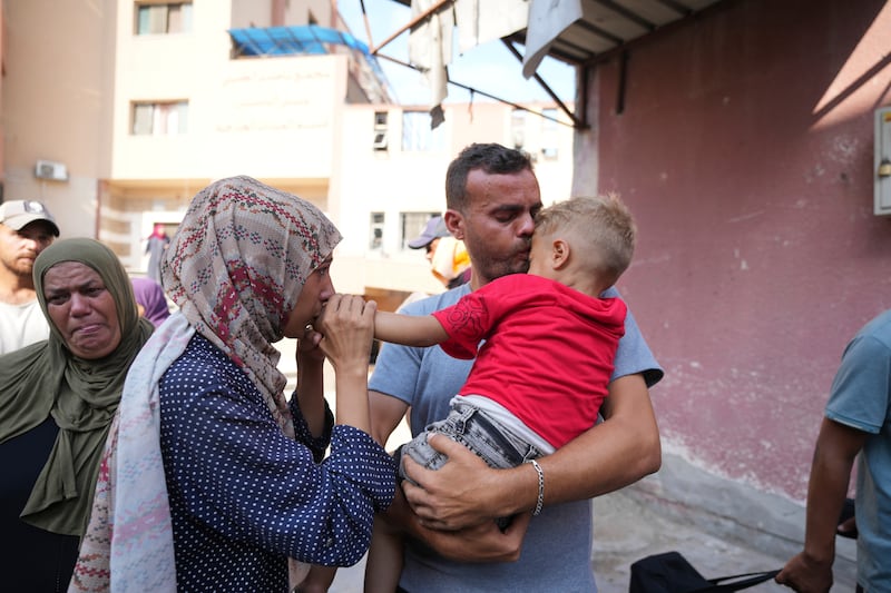 Parents embrace their sick son before he leaves the Gaza Strip for treatment abroad (Abdel Kareem Hana/AP)