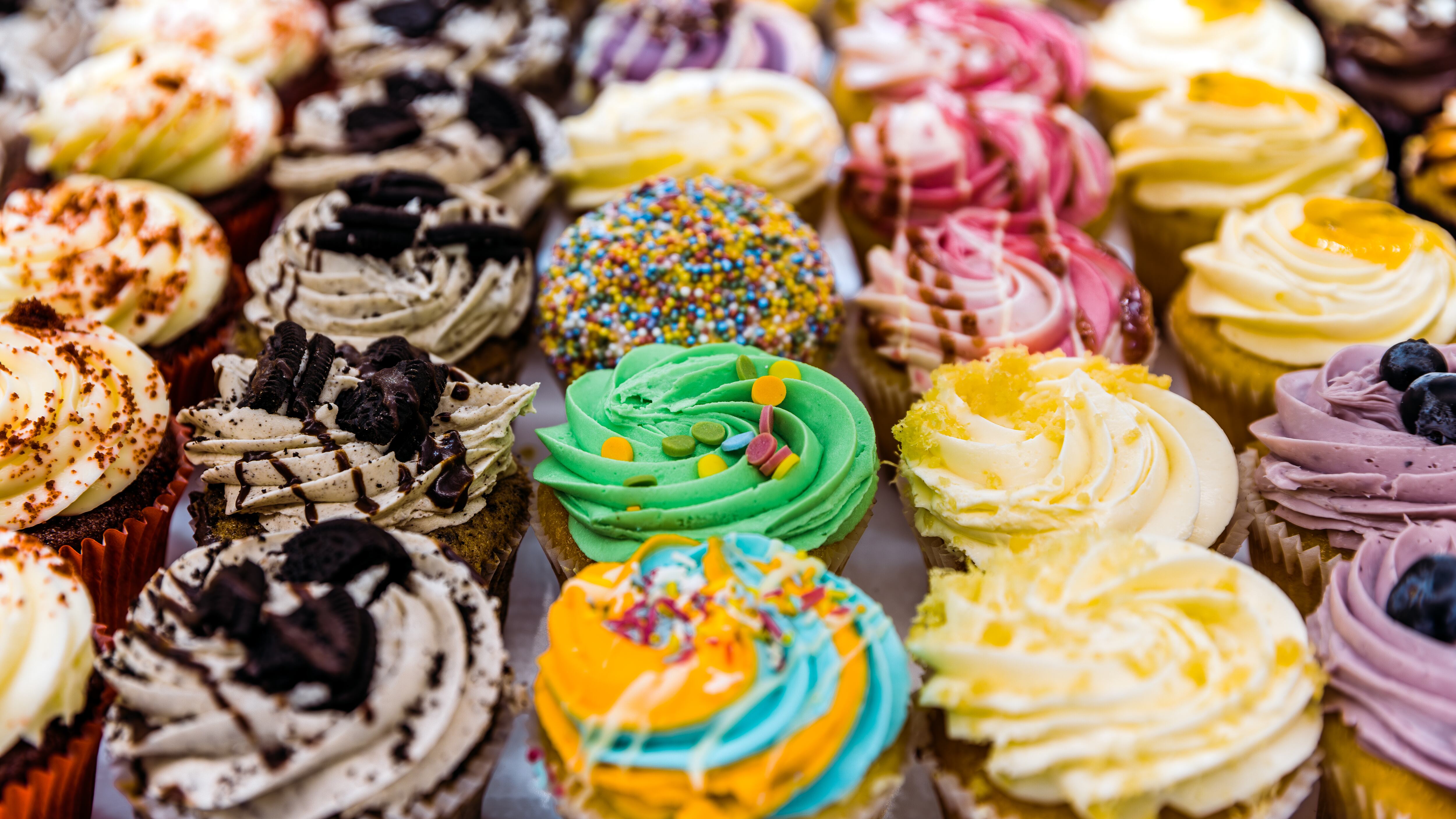 Multi-colored vibrant cupcakes for sale at the bakery