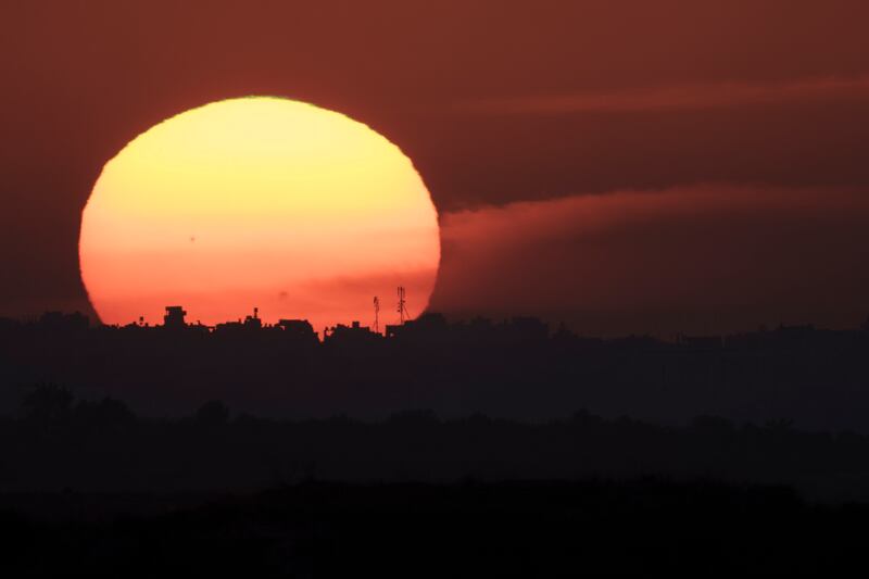 The sun sets behind buildings in the Gaza Strip on Tuesday (Leo Correa/AP)