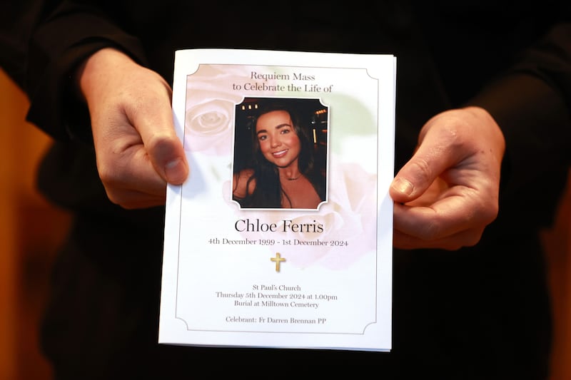 A mourner holds the order of service for the funeral of Chloe Ferris