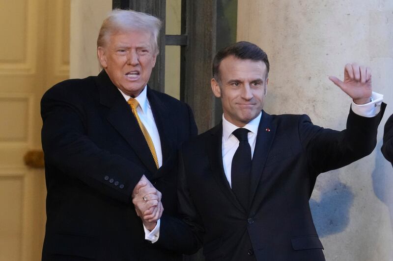 French President Emmanuel Macron, right, welcomes President-elect Donald Trump as he arrives at the Elysee Palace (Michel Euler/AP)