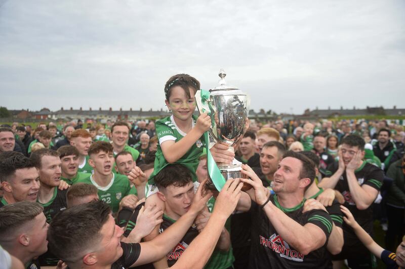 Tom McCann, son of Michael, holds the trophy as he's carried shoulder high by his Dad and team-mates following Cargin's Antrim SFC final win over Dunloy on Sunday. Picture: Mark Marlow