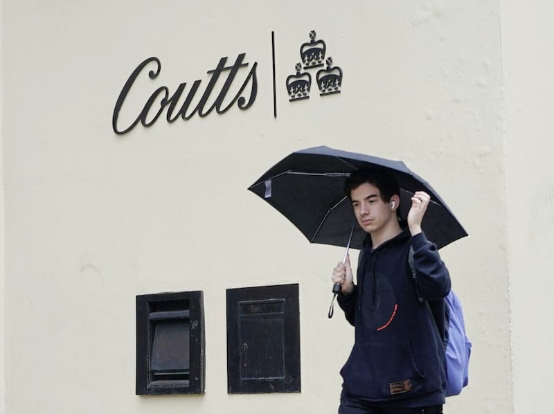 A man passes by the Coutts bank on the Strand, central London 