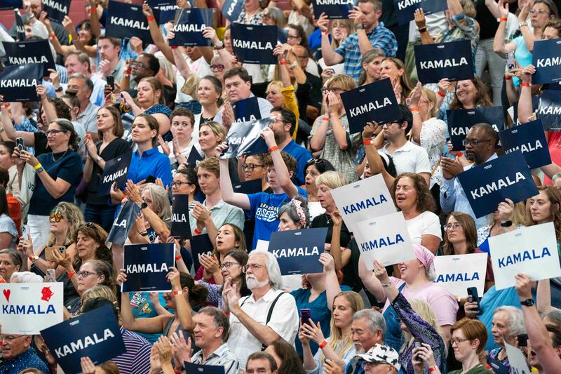 Supporters hold up signs in support of Kamala Harris (Kayla Wolf/AP)