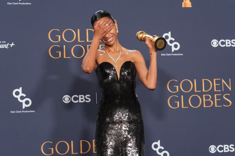 Zoe Saldana poses with the award for best performance by a female actor in a supporting role in any motion picture (Chris Pizzello/AP)