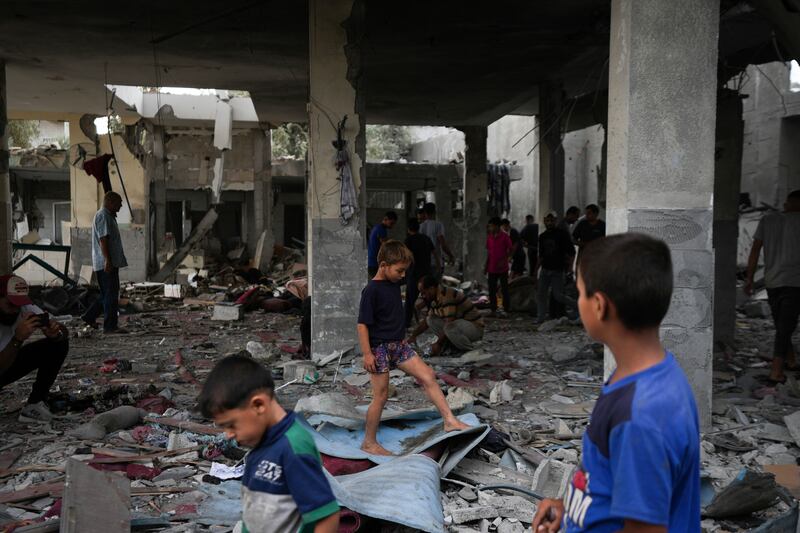 Children walk in the remains of a mosque destroyed by an Israeli airstrike in Deir al-Balah on Sunday (Abdel Kareem Hana/AP)