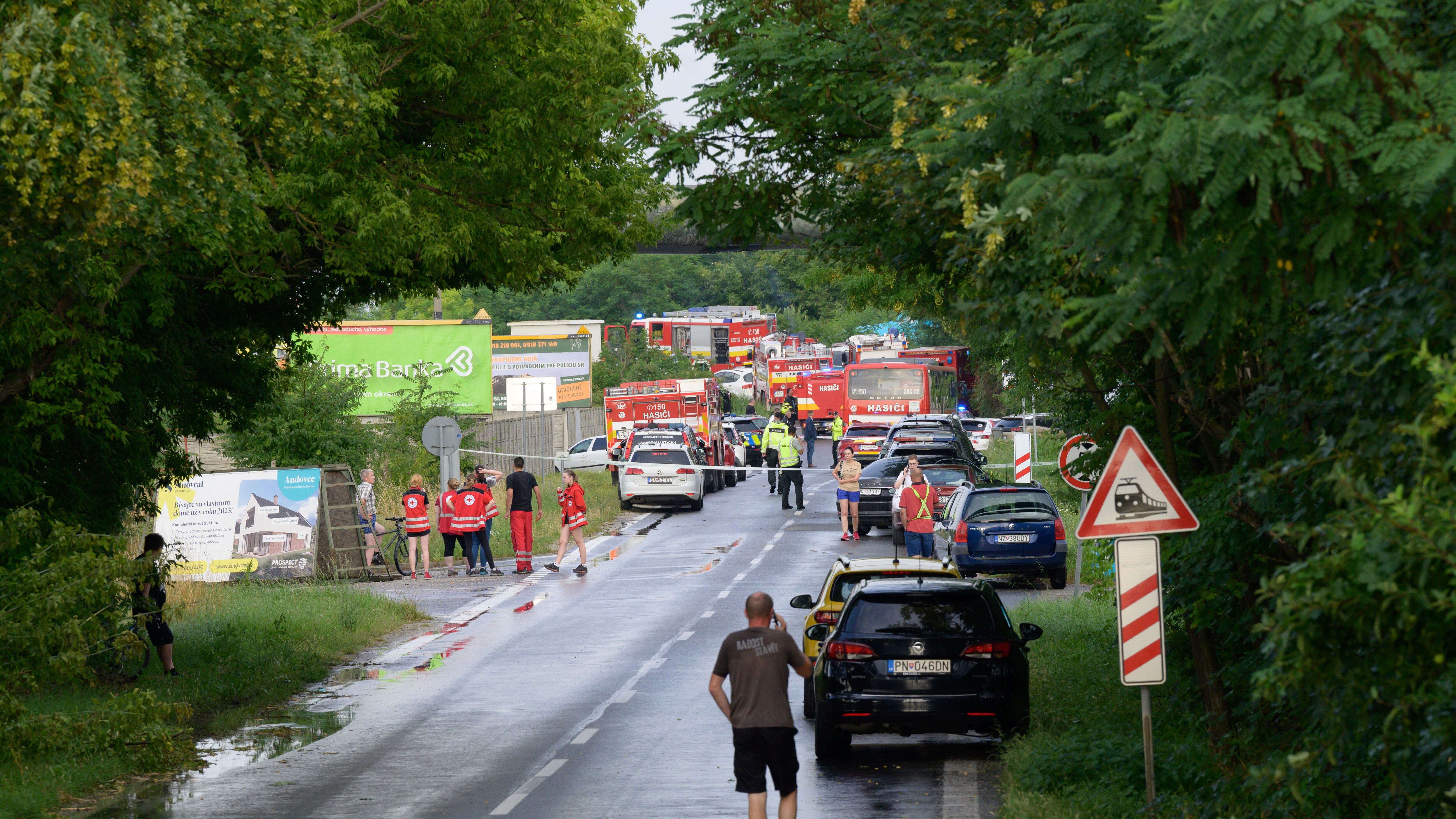 Firefighters’ vehicles and emergency vehicles on the site of the collision of a bus with a train near the town of Nove Zamky, Slovakia (Henrich Misovic/TASR via AP)