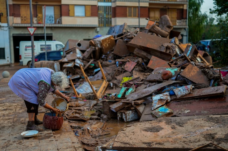 A woman cleans her house affected by floods in Utiel (Manu Fernandez/AP)