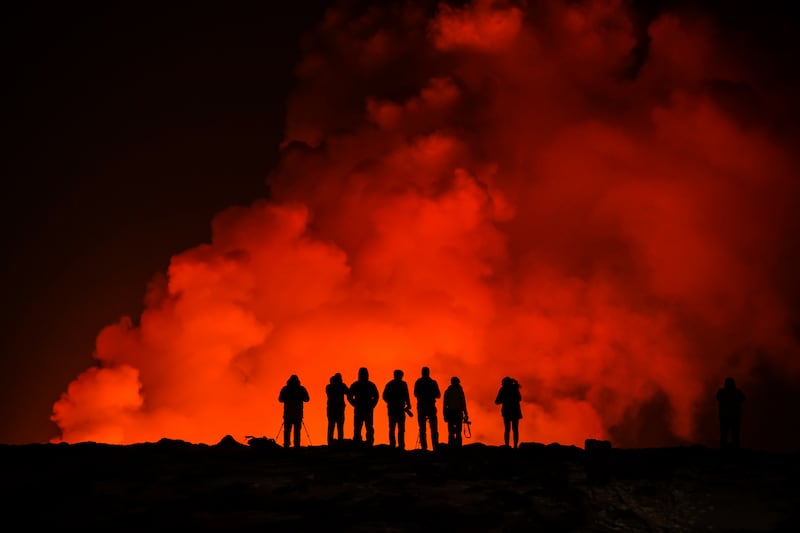 People look at the volcano erupting north of Grindavik, Iceland (Marco Di Marco/AP)