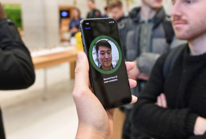 A man uses the facial recognition feature on an iPhone X in the Apple Store