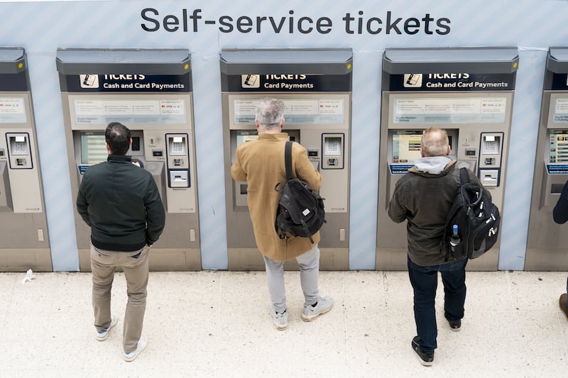 People use a ticket machine at Waterloo train station in London