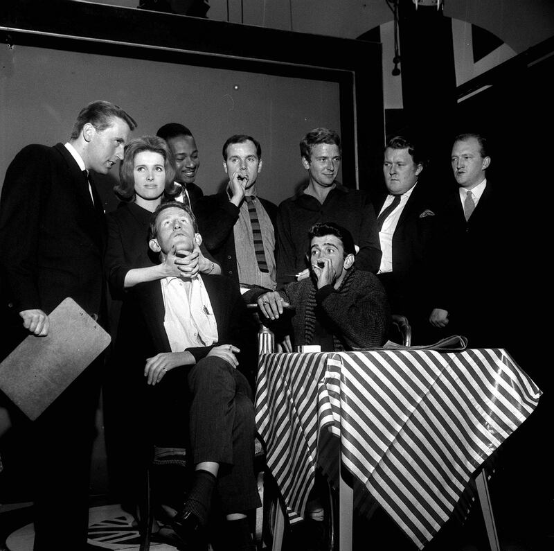 The cast of That Was The Week That Was (left to right, standing) David Frost, Millicent Martin, Irwin C Watson, Kenneth Cope, David Kernan, William Rushton and Robert Lang, and (seated) Lance Percival and Al Mancini