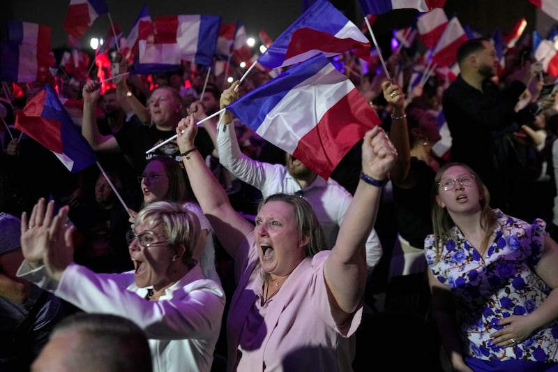 Supporters of French far right leader Marine Le Pen react after the release of projections based on the actual vote count in select constituencies (Thibault Camus/AP)