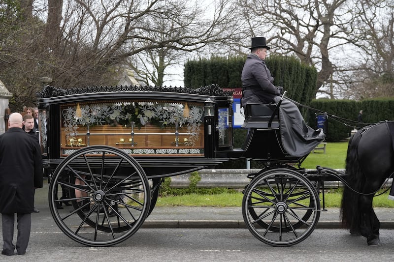 The horse-drawn carriage carrying the coffin of The Vivienne arrives at the church for their funeral