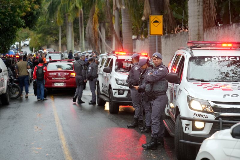 Police stand along the street leading to the gated community where a plane crashed in Vinhedo (Andre Penner/AP)