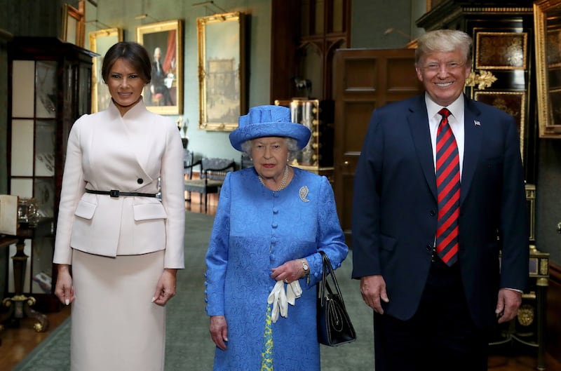 US President Donald Trump beams as he and and his wife, Melania, prepare to join the Queen for tea at Windsor