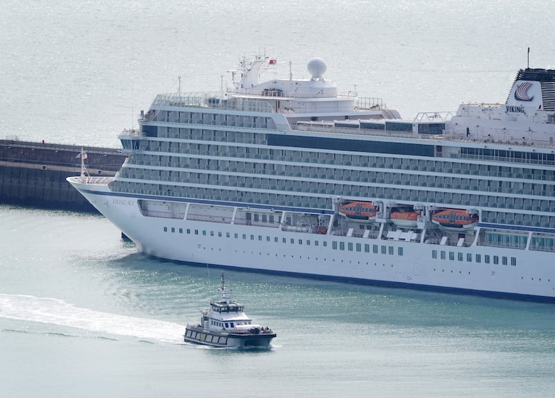 A Border Force boat passes a cruise liner docked at Dover