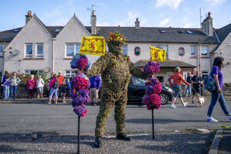 The Burryman has two staffs to help him walk through South Queensferry