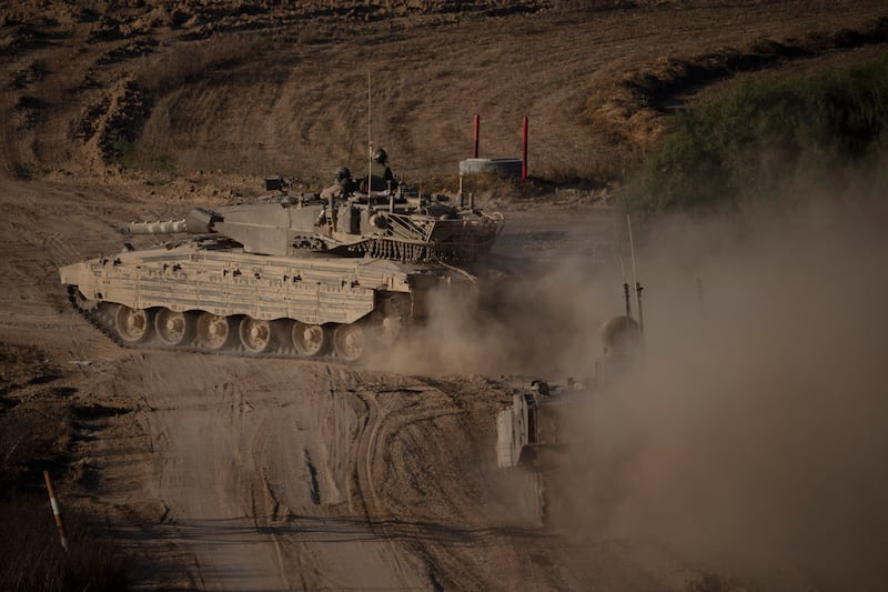 Israeli soldiers on top of a tank near the Israeli-Gaza border (Leo Correa/AP)