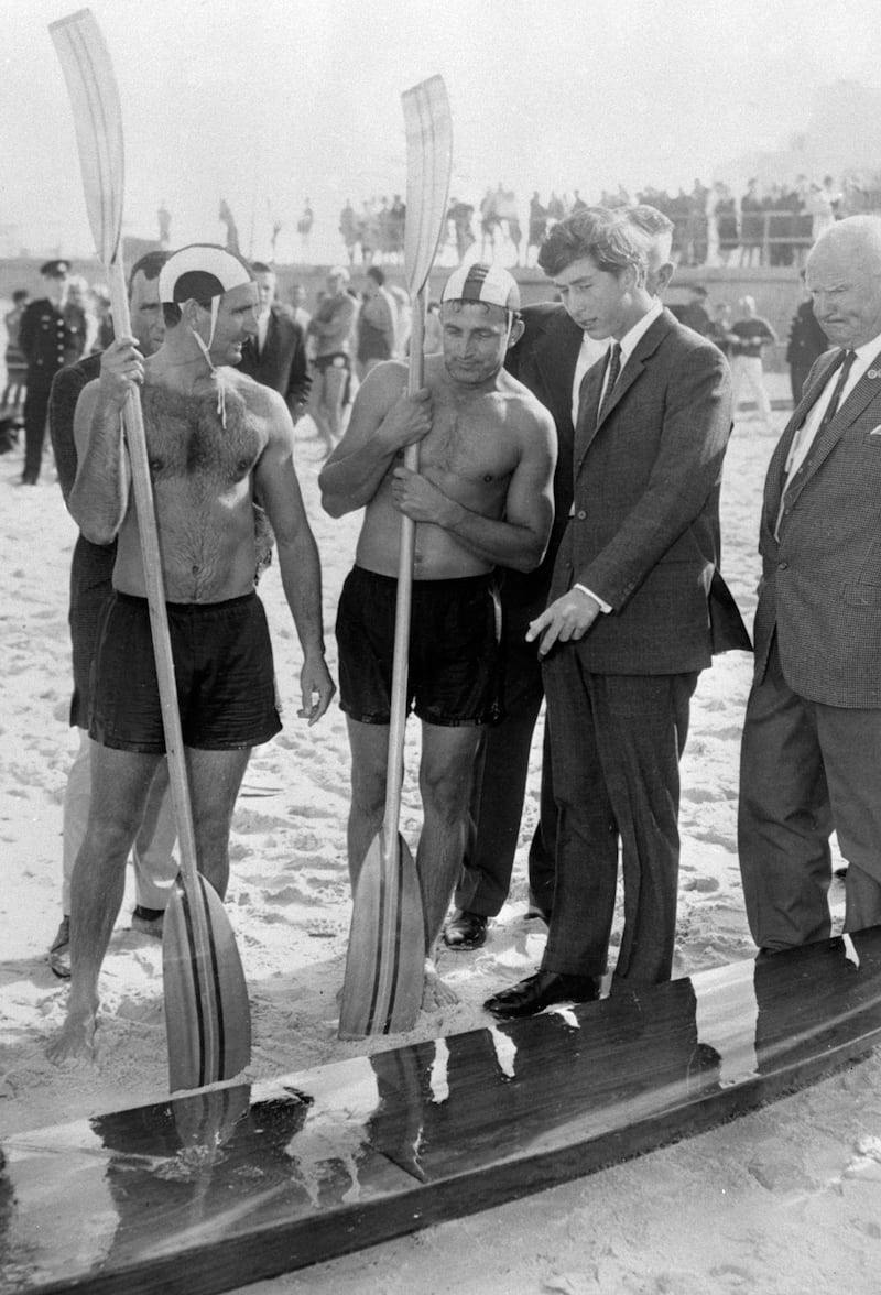 A young Charles looks at a canoe on the beach in Sydney in 1966