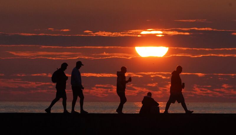 People watch the sun rise during the summer solstice at Cullercoats, North Tyneside, Tyne and Wear, North East England. (Andrew Matthews/PA Wire)