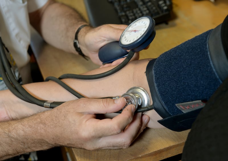 A GP checking a patient's blood pressure