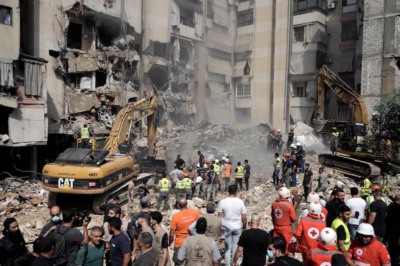 Emergency workers use excavators to clear the rubble at the site of Friday’s Israeli strike in Beirut’s southern suburbs (Bilal Hussein/AP)