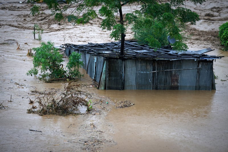 A tin shed lies partially submerged at the edge of the Bagmati River (Gopen Rai/AP)