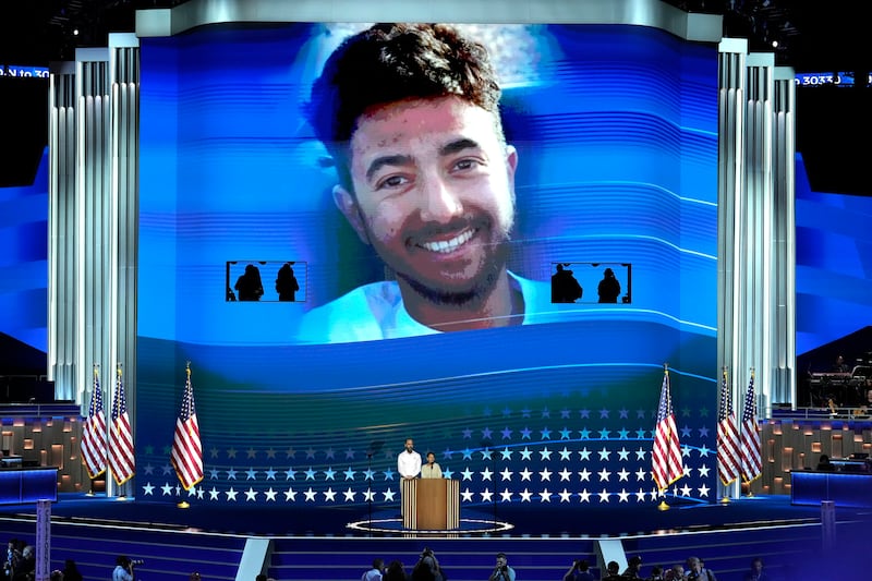 Jon Polin and Rachel Goldberg, parents of Hersh Goldberg-Polin, pictured on screen, speak during the Democratic National Convention (J Scott Applewhite/AP)