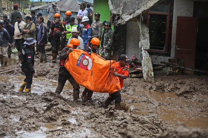 Rescuers carry the body of a victim of the landslide in Karo, North Sumatra, Indonesia (Binsar Bakkara/AP)