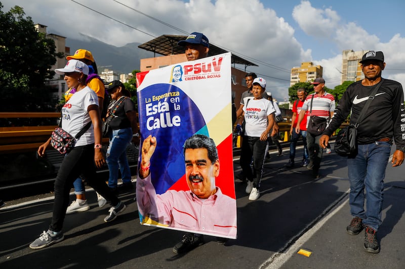 Supporters of Venezuelan President Nicolas Maduro carry a banner (Cristian Hernandez/AP)