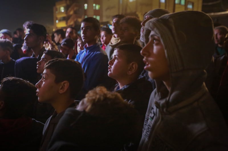 Palestinians watching TV as they awaited the announcement of the ceasefire deal between Hamas and Israel in Khan Younis, central Gaza, on Wednesday (Jehad Alshrafi/AP)