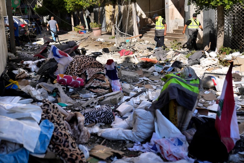 Hezbollah paramedics walk among debris after an airstrike hit an apartment in a multistory building in central Beirut (Hussein Malla/AP)