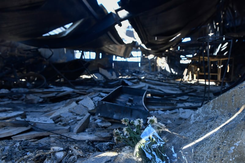 Flowers were placed inside a damaged factory where one person was found dead in the Chalandri suburb of Athens (Michael Varaklas/AP)