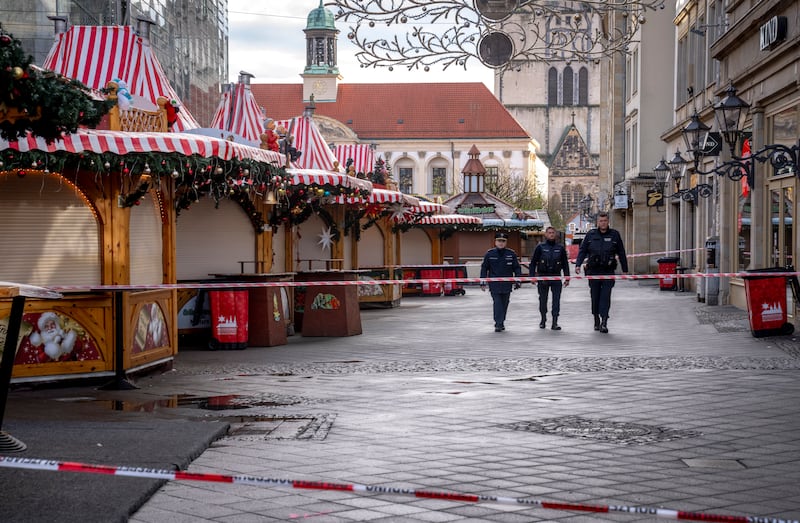 Police remain at the scene of the attack, and the Christmas market has been cordoned off (Michael Probst/AP)