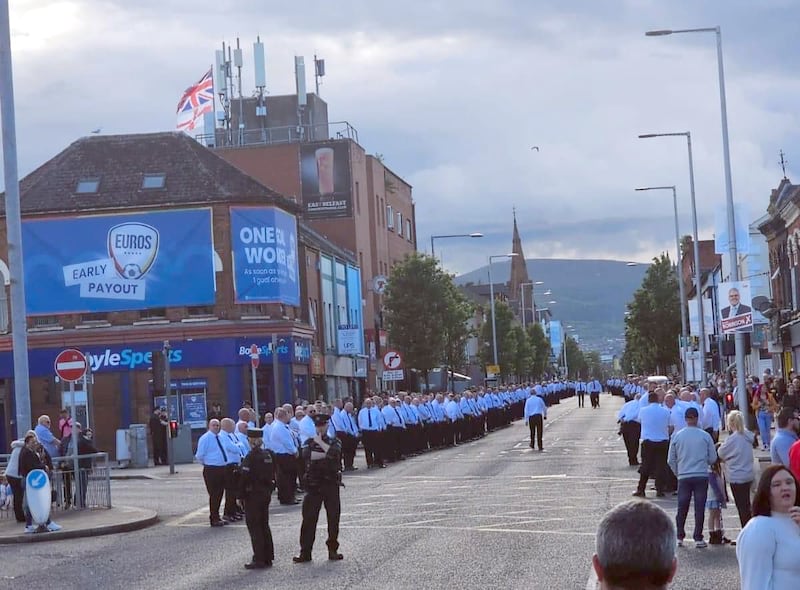 PACEMAKER PRESS 15/06/2024
Up to 700 men in white shirts and black ties line the route of a memorial parade for murdered UVF man Robert Seymour on the Newtownards Road on Saturday afternoon 16th June 2004. No byline please