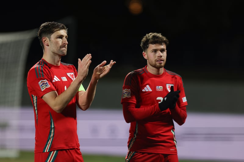 Ben Davies (left) and Neco Williams (right) appear downcast after Wales surrendered a two-goal lead to draw 2-2 in Iceland (Arni Torfason/AP)