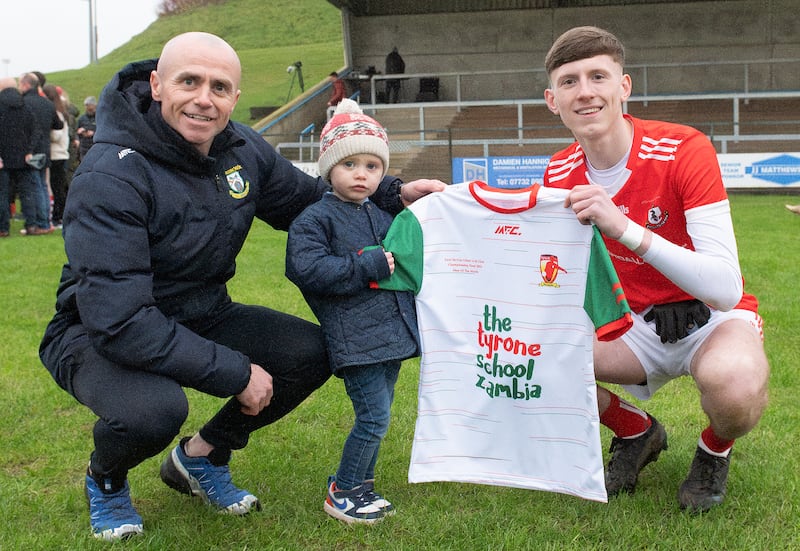 Fabian O'Neill from MFC Sports and his son Tommy present the Man Of The Match jersey to Magerafelt's Calum Leacock