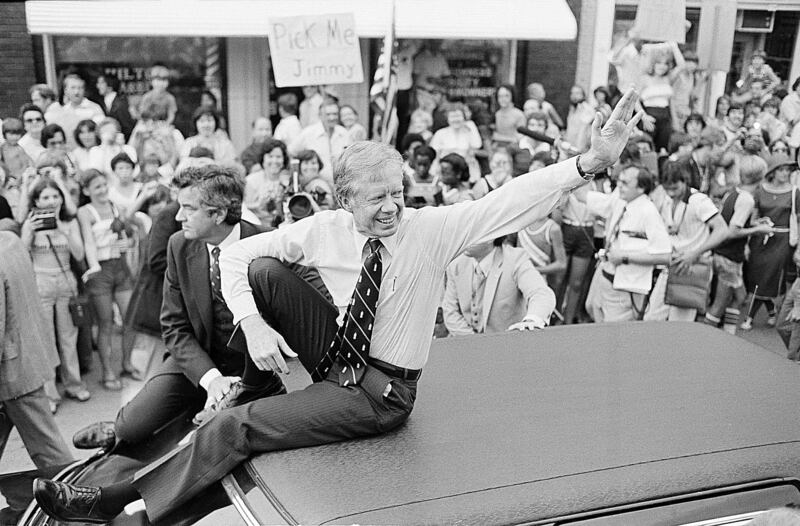 President Jimmy Carter waves from the roof of his car along the parade route through Bardstown, Kentucky (Bob Daugherty/AP)